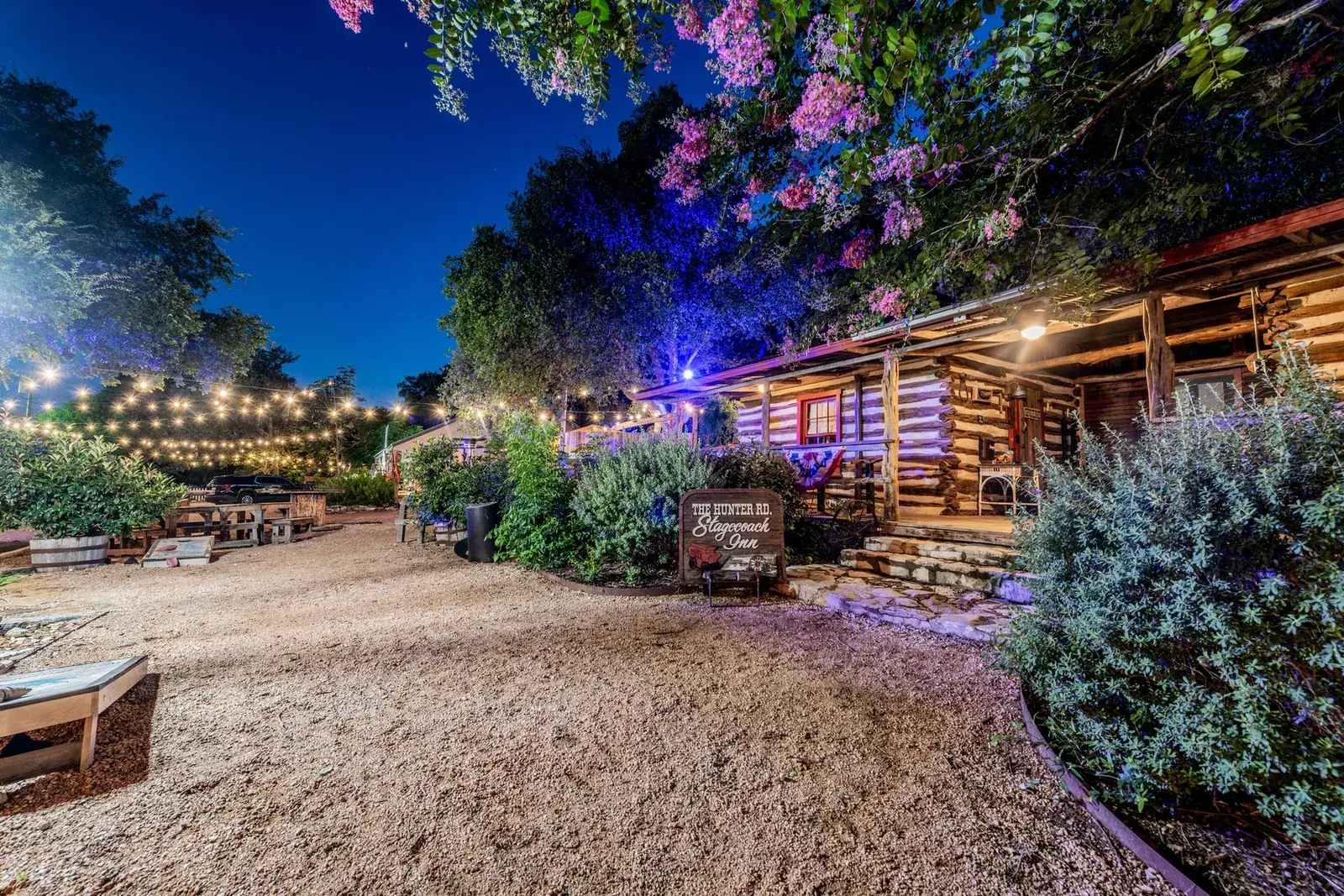 Gravel grounds and landscaped beds glowing under evening lights